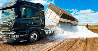 caminhao scania cacambas basculantes descarregando calcario na lavoura