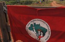 bandeira do mst pendurada na porteira da fazenda