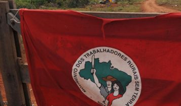bandeira do mst pendurada na porteira da fazenda