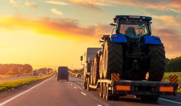 maquinas agricolas transportadas por prancha em rodovia