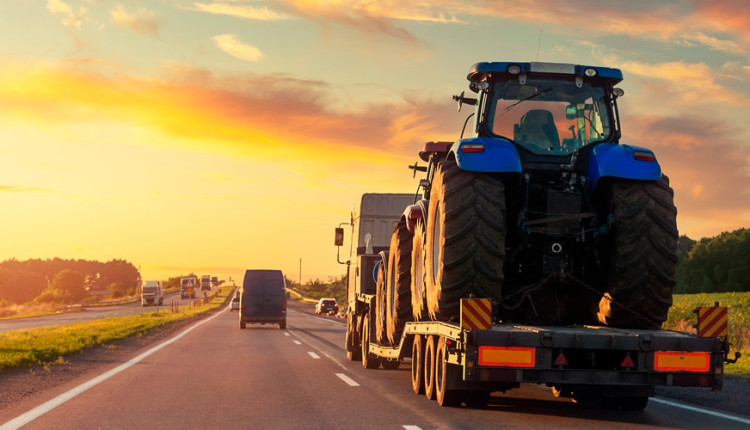 maquinas agricolas transportadas por prancha em rodovia