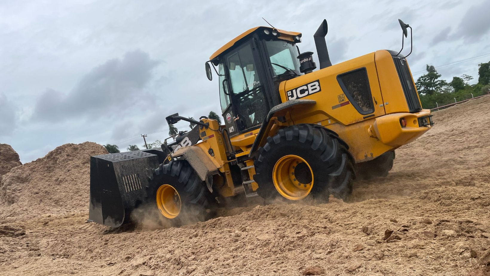 pa carregadeira da JCB trabalhando com bagacinho de cana